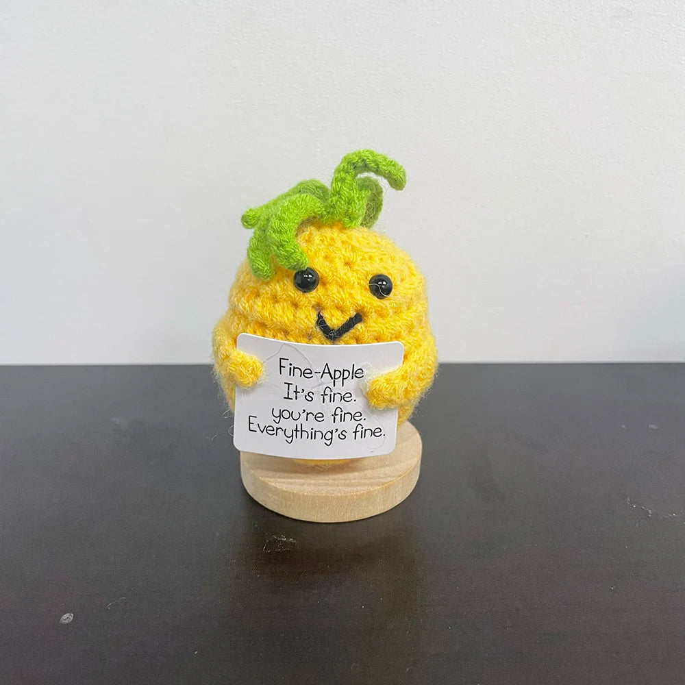 Yellow crochet pineapple plush with green top, smiling face, and a sign that says "Fine-Apple. It's fine. You're fine. Everything's fine.